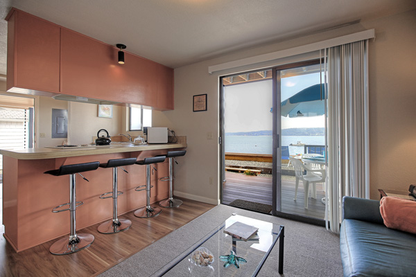 Sliding glass doors lead from the living room of The Beach House at Tyee to a spacious deck just step away from Tyee's sand and gravel beach on Camano Island.