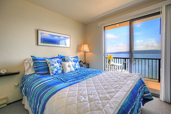 The upstairs bedroom at The Beach House at Tyee has sliding glass doors leading to a balcony overlooking Port Susan Bay on Camano Island.