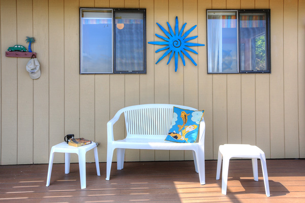 A comfy loveseat on the deck at The Beach House at Tyee is a perfect place to curl up with a book