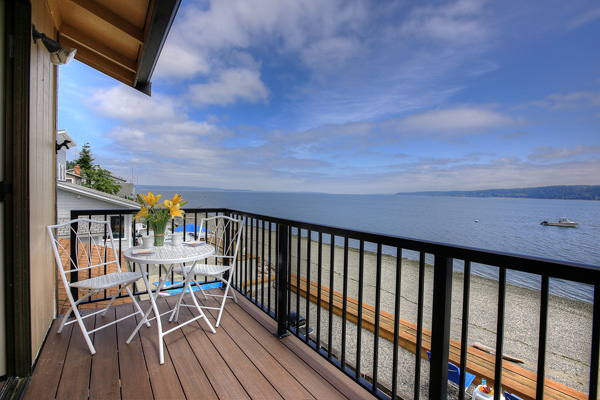 The upstairs balcony at The Beach House at Tyee on Camano Island has two chairs and a table, as well as fabulous views of Port Susan Bay and the Cascade Mountains.